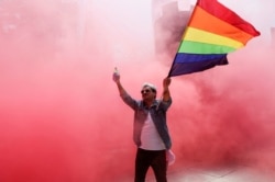 ЛГБТ туын ұстап бара жатқан адам. Көрнекі сурет.