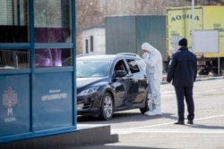 Молдовські прикордонники вимірюють температуру водіїв та пасажирів на кордоні Молдови. 14 березня 2020 року