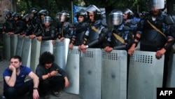 Armenia -- Demonstrators sit on a street in front of a line of riot police during a protest against an increase of electricity prices in Yerevan, June 24, 2015