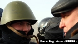 Лидер оппозиционной партии "Алга" Владимир Козлов разговаривает с полицейским на центральной площади города Актау. 21 декабря 2011 года.