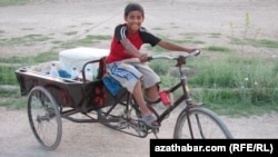 Türkmenabat şäheriniň köçelerinde süýt satyp ýören oglanjyk. Türkmenabat, maý, 2012.