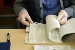 Член избирательной комиссии в Баварии надел перчатки из-за начавшейся эпидемии во время коммунальных выборов 15 марта