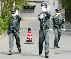 Милиция кызматкерлери Бээжин шаарындагы оорукананы сүрөткө тартууга болбоорун ишаарат кылууда. Апрель, 2003-жыл.