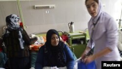 یک نرس قابله در هنگام معاینه یک بانوی که طفل نوزاد به دنیا آورده است