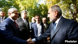 Armenia -- Prime Minister Nikol Pashinian (R) greets Aram Sarkisian at a memorial to the victims of the October 1999 deadly attack on the Armenian parliament, Yerevan, October 27, 2019.