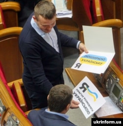 Народний депутат Іван Крулько у Верховній Раді в День української писемності та мови демонструє колезі листівки. Київ, 4 листопада 2016 року
