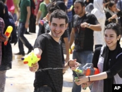 Молодые люди стреляют из водяных пистолетов. Тегеран, 29 июля 2011 года.