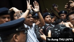 Полиция "Reuters" агенттигинин журналисти Ва Лоунду өкүм угузулгандан кийин сот залынан чыгарып баратат, Янгон, 3-сентябрь 2018-жыл.