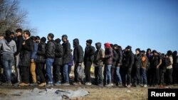 Migrants wait to receive free food near the Serbian-Hungarian border outside the town of Subotica last month.