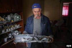 Чоловік тримає залишки ракетного снаряда. Дебальцеве, 22 вересня 2014 року