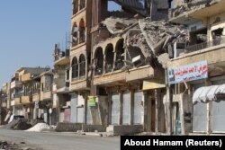 Siriýanyň Rakka şäherinde bomba partlamasynyň zarbyna weýran bolan bina.
