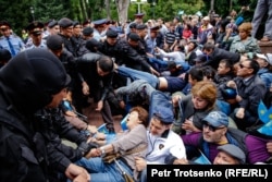 Полицейские задерживают людей на площади в центре Алматы. 9 июня 2019 года.