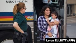 Баласын көтөргөн мигрант аял. 17-июнь, 2018-жыл. Техас.
