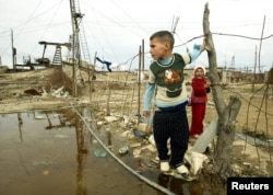 Дети играют на задворках нефтяного месторождения на окраине Баку. 8 ноября 2005 года.