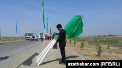 Illýustrasiýa suraty. Bir köpçülik çäresinde baýdaklary ýygnaýan býujet işgäri. 