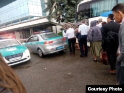 Делегаты регионального Конгресса Свидетелей Иеговы садятся в автобус, рядом – полицейские машины. Фото предоставлено «Христианским Центром Свидетелей Иеговы» в Алматы. 24 июня 2017 года.