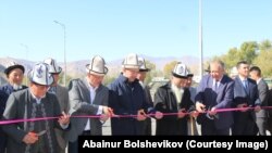 Кубатбек Боронов и Улан Примов перерезают красную ленту в присутствии местных жителей. 15 октября 2019 г.