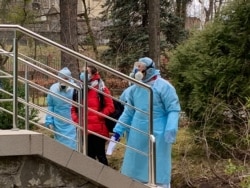 Медики супроводжують пацієнтку на огляд