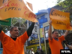 Журналисты Сергей Дуванов и Рысбек Сарсенбай вышли на улицу поддержку Евгения Жовтиса, которого судили после ДТП. Они держат плакаты «Сегодня Жовтис, завтра — вы». Алматы, 23 сентября 2009 года