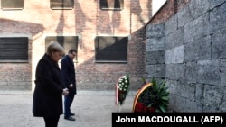 Канцлерка Німеччини Ангела Меркель та прем'єр-міністр Польщі Матеуш Моравецький поклали вінки до Стіни смерті під час свого візиту в колишній німецький нацистський табір смерті «Аушвіц-Біркенау» в Освенцимі, Польща. 6 грудня 2019 року