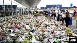 Самолëт уриб туширилганидан озгина ўтиб¸ Амстердамдаги Схипхол аэропорти ëнига келган одамлар қурбонлар хотираси учун гул қўймоқда. Ҳалок бўлган 298 йўловчидан 200га яқини Нидерландия фуқароси эди.