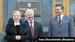 Колишній прем'єр-міністр України Юлія Тимошенко (ліворуч), лідер Соціалістичної партії Олександр Мороз (посередині) і головний лідер опозиції Віктор Янукович посміхаються під час розмови з журналістами після зустрічі з президентом Віктором Ющенком. Київ, 11 квітня 2006 року