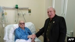 Польшадагы эркиндиктин символу, Нобелдин тынчтык сыйлыгынын лауреаты, экс-президент Л. Валенса (оңдо) коммунисттик Польшанын лидери Я. Ярузельский менен кол алышып турат. Варшавагы оорукана. 24-сентябрь 2013