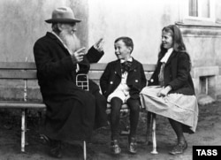 Жазууучу Лев Толстой неберелери Соня менен Ильюшага жомок айтып берүүдө. Ясная Поляна жергеси, падышалык Орусия.