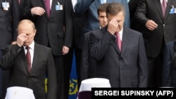 Президент Росії Володимир Путін (ліворуч) і тодішній президент України Віктор Янукович (праворуч) хрестяться під час богослужіння, приуроченого до 1025-річчя Хрещення України-Русі. Київ, 27 липня 2013 року