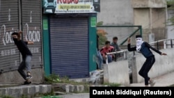 شماری از جوانان کشمیر حین پرتاب سنگ بالای نظامیان هندی