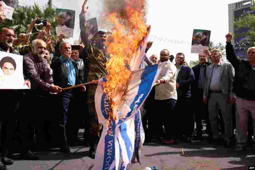 Иран башкаласы Тәһранның Фәләстин мәйданында протест чарасы вакытында катнашучылар Израил байракларын яндыра. Алар Израилнең узган айда Газзә сызыгында башлап җибәргән зур хәрби операцияләрен тәнкыйтьли.