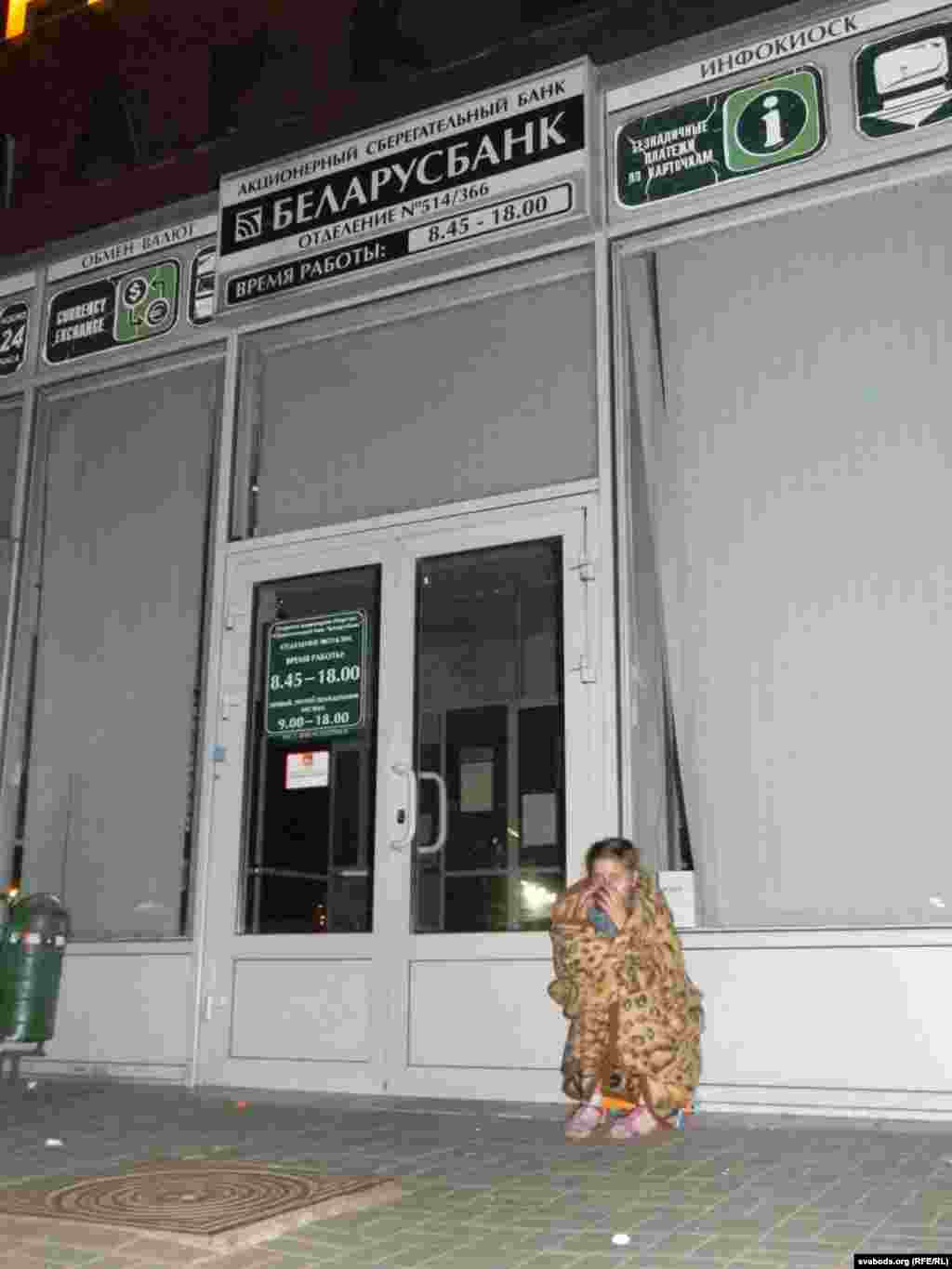 Зьміцер Бараноўскі - Дзяўчынка пад коўдрай і з кавай у руцэ ў чарзе ля абменьніка.