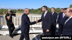 Armenia/Turkey - Armenian parliament vice-speaker Ruben Rubinian (right) greets Turkish envoy Serdar Kilic on a Turkish-Armenian border bridge, September 12, 2025.