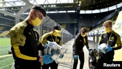 Хлопці, які подають м’ячі, перед центральним матчем туру в Німеччині, «Боруссія» (Дортмунд) – «Шальке», 16 травня 2020 року