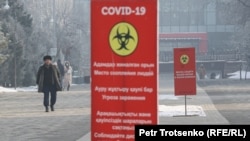 Алматы көшесіндегі Covid қаупі жайлы ескерту жазылған баннер.  Көрнекі сурет.