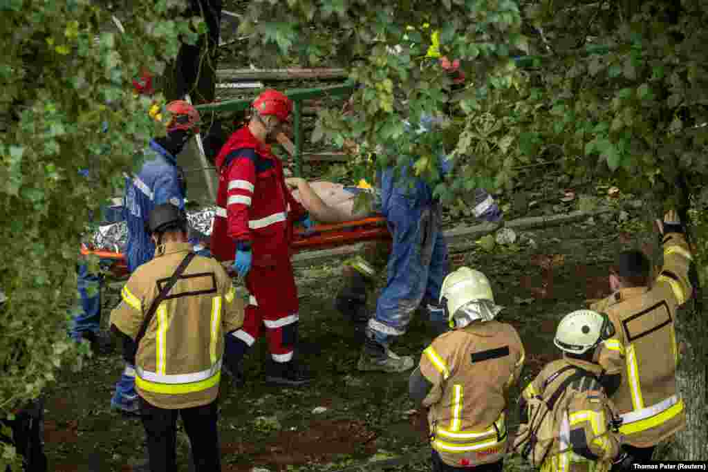 Рятувальники несуть чоловіка, якого вдалося врятувати з-під завалів будинку.Рятувальники підтримували з ним контакт понад три години. Чоловік провалився з другого поверху на перший і його затисло конструкціями, повідомив міністр внутрішніх справ Ігор Клименко. До постраждалого важко діставалися: рятувальники пробили отвір у стіні сусідньої квартири і сформували своєрідний тунель. На чоловіка наклали спеціальні фіксатори, щоб не нашкодити під час порятунку», – написав він