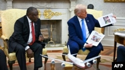Президент США Дональд Трамп під час зустрічі з президентом Південної Африки Сирілом Рамафосою в Білому домі показує фотографії на тему переслідування білих у ПАР, Вашингтон, 21 травня 2025 року
