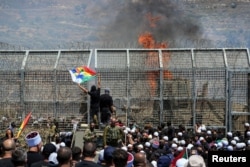 Друзы стоят по обе стороны фактической границы между Израилем и Сирией в разгар конфликта в друзских районах Сирии. Мадждаль-Шамс, рядом с Голанскими высотами. 16 июля 2025 года