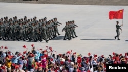 Hytaýyň Halk-azat ediş armiýasynyň soldatlary 2019-njy ýylda, Halkara goşun oýunlarynyň açylyş dabarasyna taýýarlyk görýär. Korla, Sinjiang-Uýgur awtonom etraby, Hytaý, 2019-njy ýylyň 3-nji awgusty.