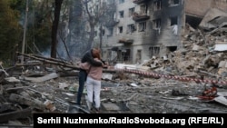 На месте российского ракетного удара по Киеву. По сообщениям, у этих людей в этом подъезде жил сын. 17 июня 2025 года