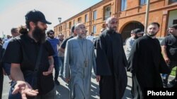 Armenia - Archbishop Mikael Ajapahian (second from left) leaves the Echmiadzin headquarters of the Armenian Apostolic Church for a law-enforcement agency in Yerevan, June 27, 2025.