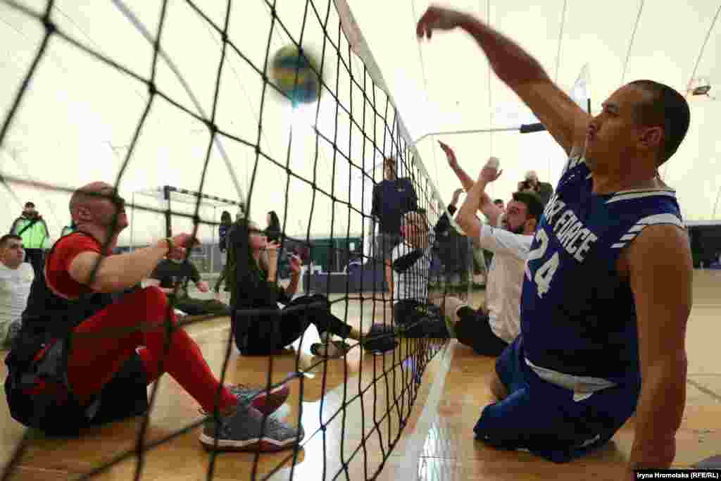 Учасники американської й української команд грають у сидячий волейбол