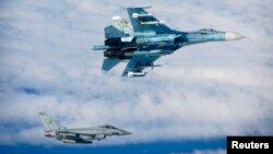 Російський Су-27 (зверху) поруч з британським винищувачем Тайфун у міжнародному повітряному просторі недалеко від Балтії, червень 2014 року