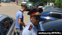 Полицейский у офиса Казахстанского бюро по правам человека, где было совершено нападение на журналистов, в том числе репортеров Азаттыка. Алматы, 22 июля 2019 года.