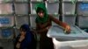 An Afghan election worker cuts a security seal to unlock a ballot box before counting ballot papers during an audit of the presidential runoff in Kabul on August 3.