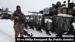 Украинский военнослужащий возле разбитой под Харьковом в начале марта 2022 года колонны военной техники 200-й мотострелковой бригады