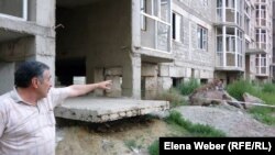 Житель жилого комплекса «Бесоба» Альберт Камуков показывает на появившиеся трещины и отклонения в доме №4. Караганда, 24 июля 2012 года.