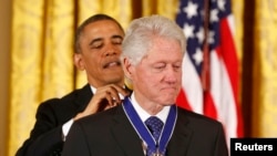 АҚШ президенті Барак Обама бұрынғы президент Билл Клинтонға (оң жақта) "Бостандық" медалін тағып тұр. Вашингтон, 20 қараша 2013 жыл.