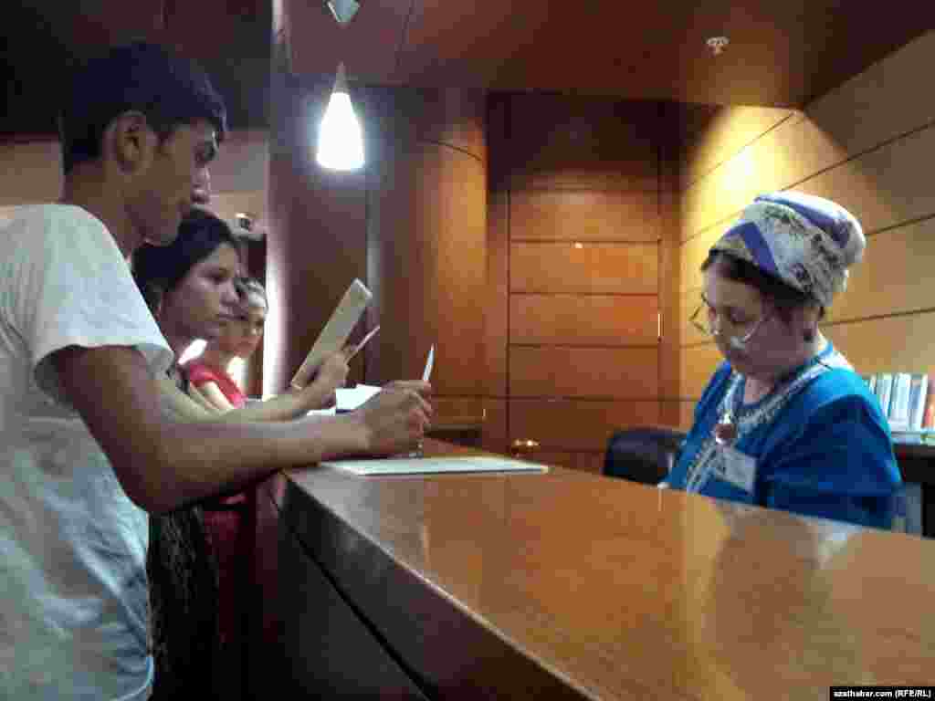 Ýörite kartoçkany dolduryp, zerur kitaplary almak üçin nobata duran adamlar