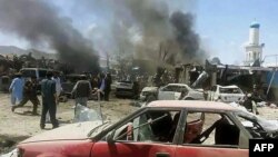 Afghan security personnel are pictured past mangled cars at the scene of a suicide attack at a busy market in Urgun district, Paktika Province, on July 15. 